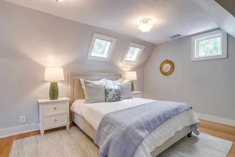 a bedroom with a large bed and wooden floor