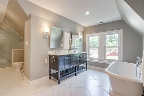 a spacious bathroom with a tub a sink and a window