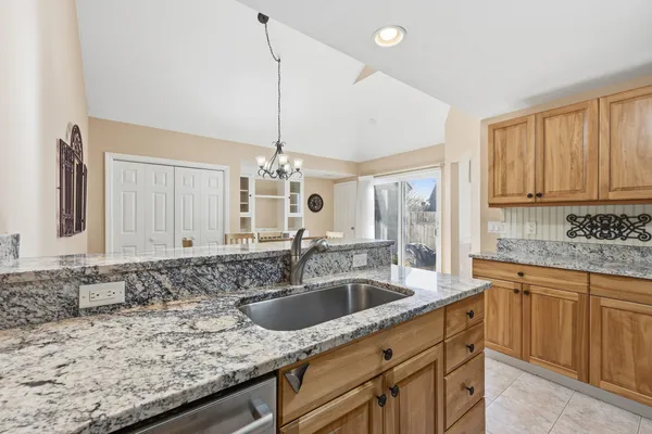 a kitchen with granite countertop a sink a counter space appliances and cabinets