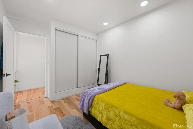 a bedroom with a bed and wooden floor