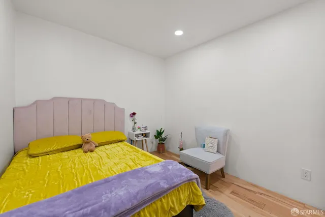 a room with a bed and wooden floor