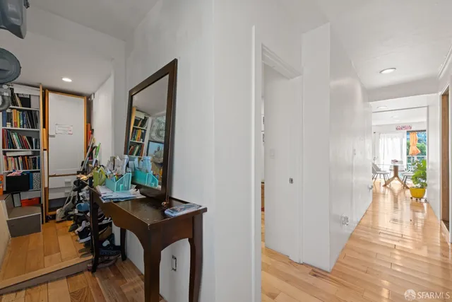 a view of a hallway with workspace and living room