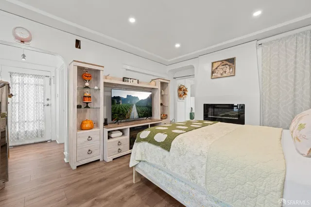 a bedroom with a large bed and a flat tv screen on dresser