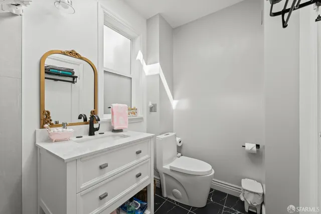a bathroom with a toilet sink and mirror