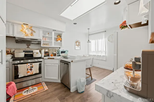 a kitchen with stainless steel appliances granite countertop a stove and a refrigerator