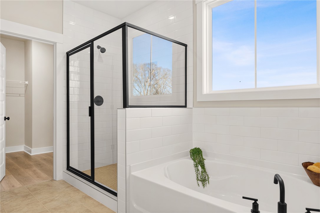 3401 Split Oak Circle Seneca, SC 29678 - Photo 8 of 8 This bright bathroom features a spacious tub and a glass-enclosed shower, perfect for a relaxing retreat.