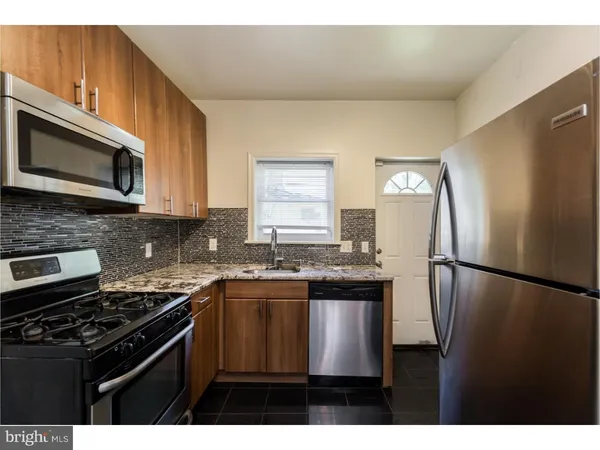 a kitchen with stainless steel appliances granite countertop a stove a refrigerator and a microwave