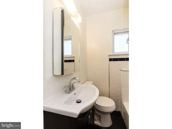 a bathroom with a sink toilet and mirror