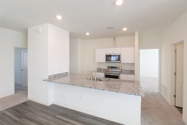 a kitchen with stainless steel appliances granite countertop a refrigerator and a sink