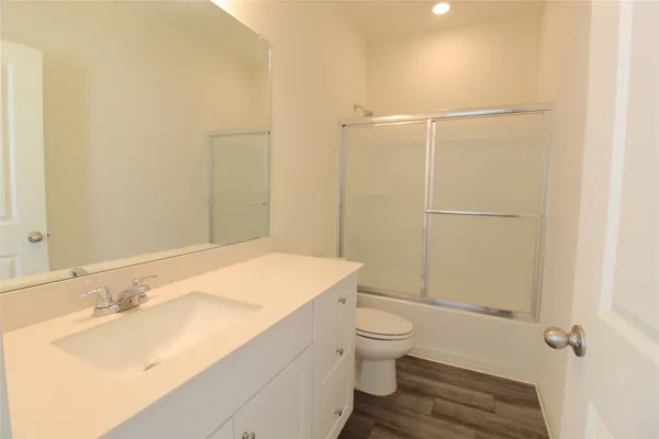 a bathroom with a sink toilet vanity and shower