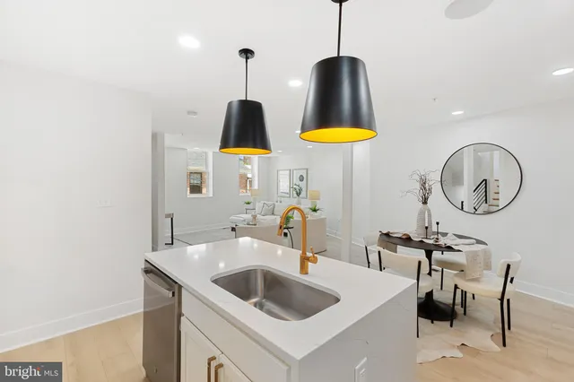 a kitchen with stainless steel appliances a sink a counter space and a view of living room