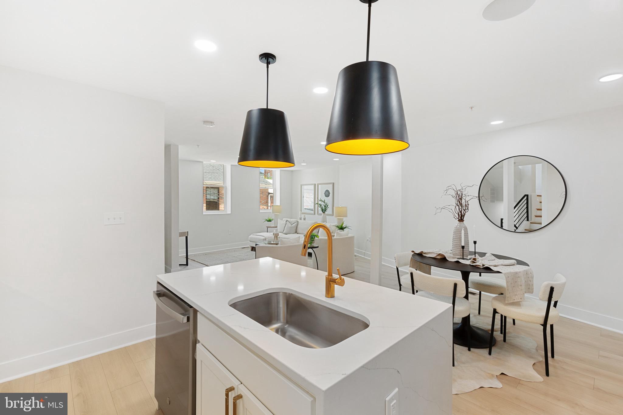 1601 Portugal Street Baltimore, MD 21231 - Photo 16 of 45 a kitchen with stainless steel appliances a sink a counter space and a view of living room