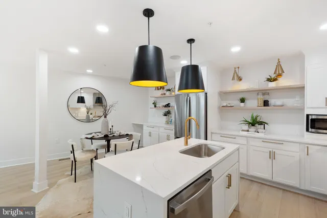 a kitchen with a sink a stove and chairs