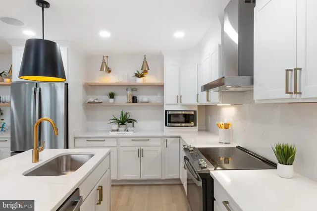 a kitchen that has a sink a stove and cabinets