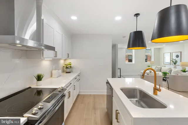 a kitchen with stainless steel appliances a sink a stove and a wooden floor