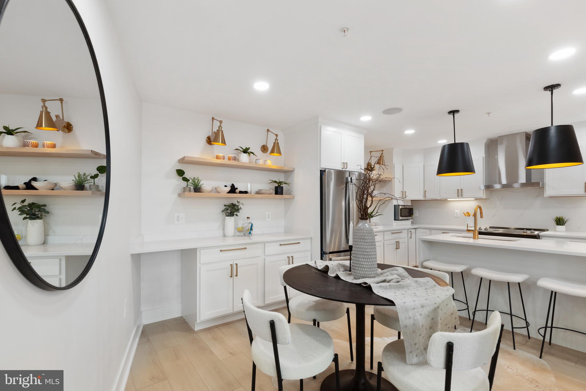 1601 Portugal Street Baltimore, MD 21231 - Photo 22 of 45 a kitchen with stainless steel appliances granite countertop a sink a stove a microwave a dining table and chairs with wooden floor