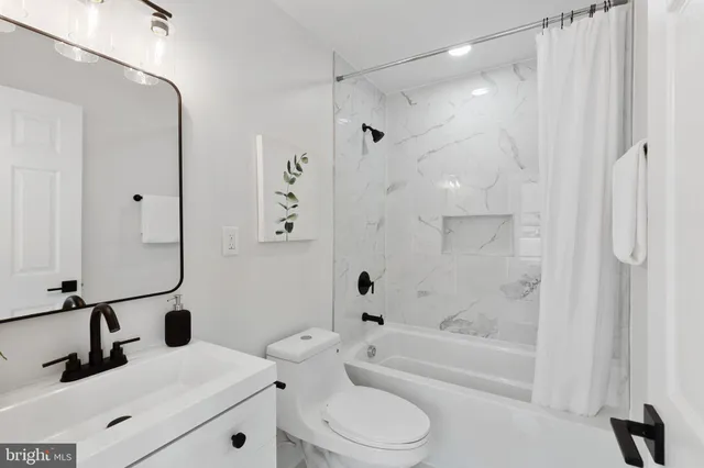 a bathroom with a bathtub shower sink vanity and toilet