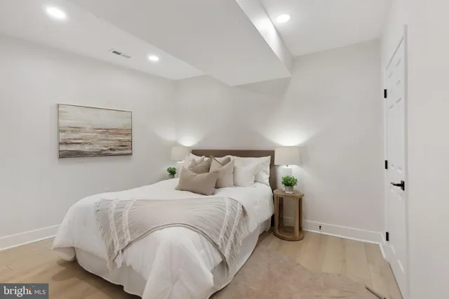 a bedroom with a bed and a painting on the wall