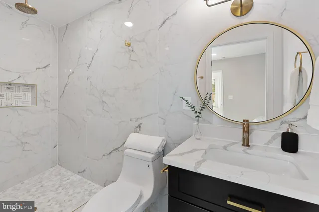 a bathroom with a sink a toilet and a mirror