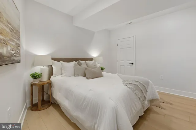 a large bed sitting in a bedroom next to a lamp