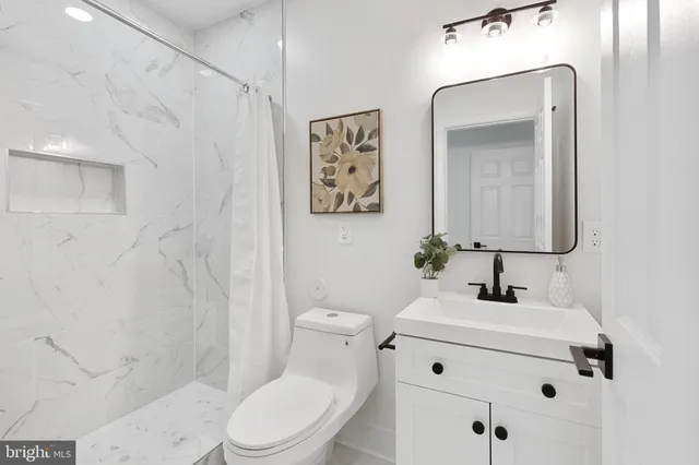 a bathroom with a sink mirror vanity and toilet