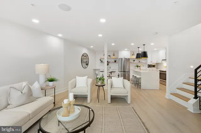 a living room with furniture and a dining table with kitchen view