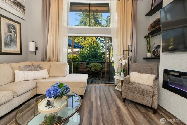 a living room with furniture fireplace and a large window