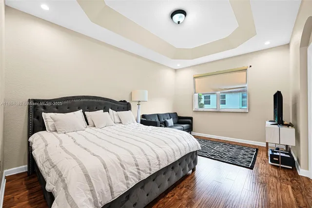 a bedroom with a bed and a flat screen tv