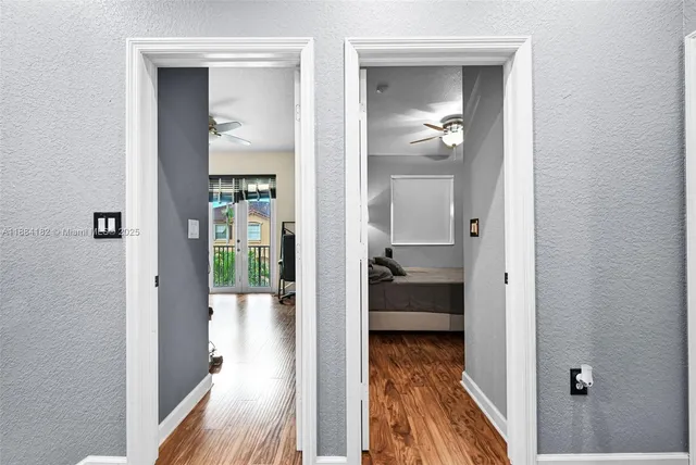 a view of a hallway with wooden floor and a potted plant