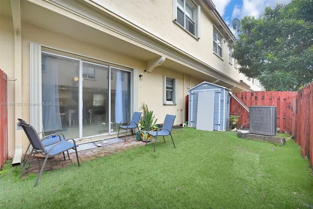 a view of a chair and table in backyard of the house