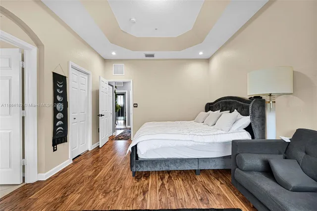 a bedroom with a bed and a wooden floor