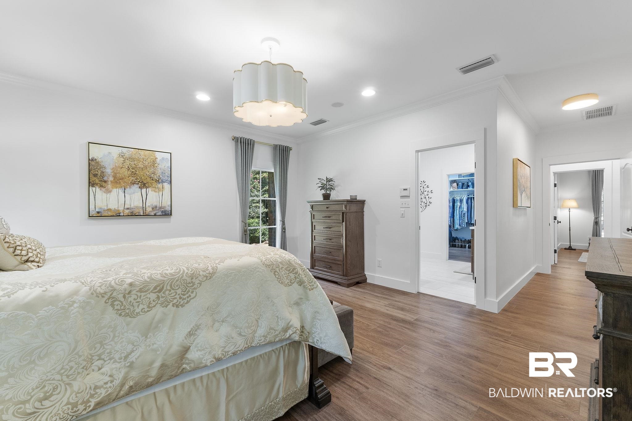 4451 Millhouse Road Gulf Shores, AL 36542 - Photo 28 of 50 Bedroom with a closet, ornamental molding, hardwood / wood-style floors, and a walk in closet