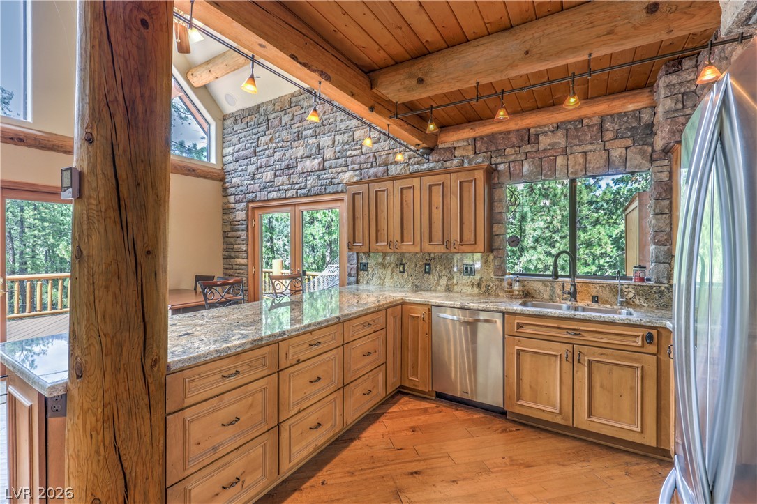 322 Ski Trail Road Mount Charleston, NV 89124 - Photo 11 of 58 Exposed log columns and natural stone accents frame this rustic mountain kitchen.
