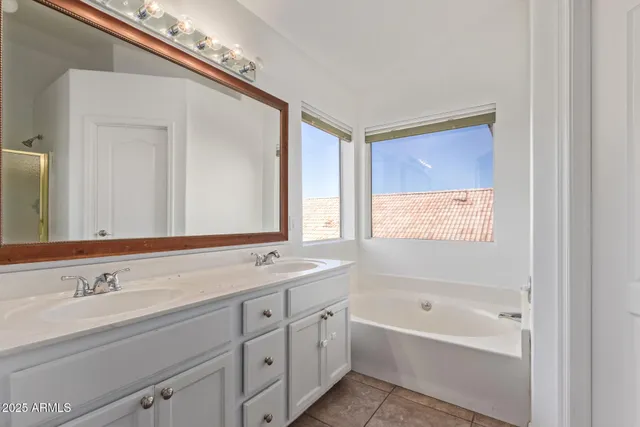 a bathroom with a tub a sink and a window