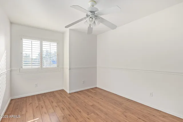 an empty room with a window and a ceiling fan