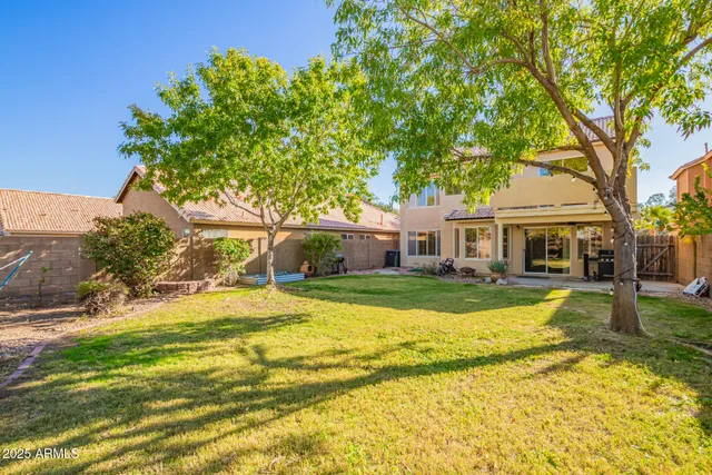 a view of a house with a big yard and large trees