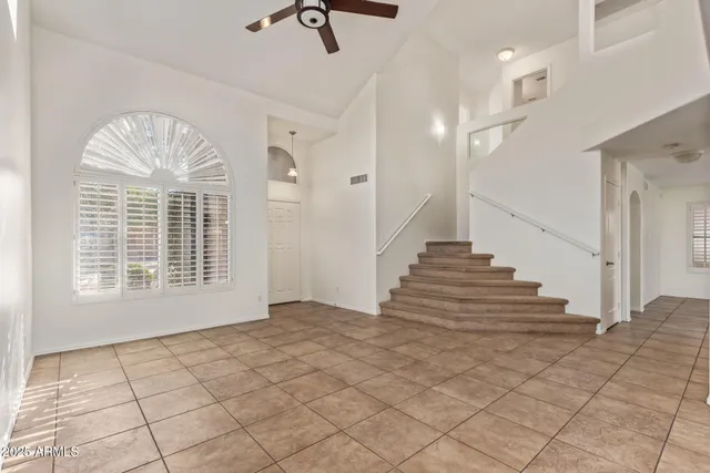 a view of staircase with white walls and chandelier