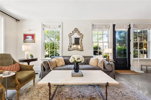 a living room with fireplace furniture and large windows