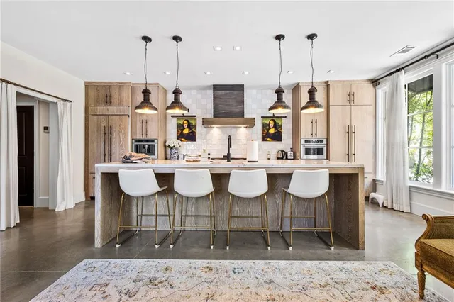a kitchen with a dining table chairs and white cabinets
