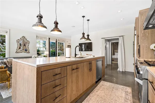a kitchen with stainless steel appliances granite countertop a sink a stove and refrigerator