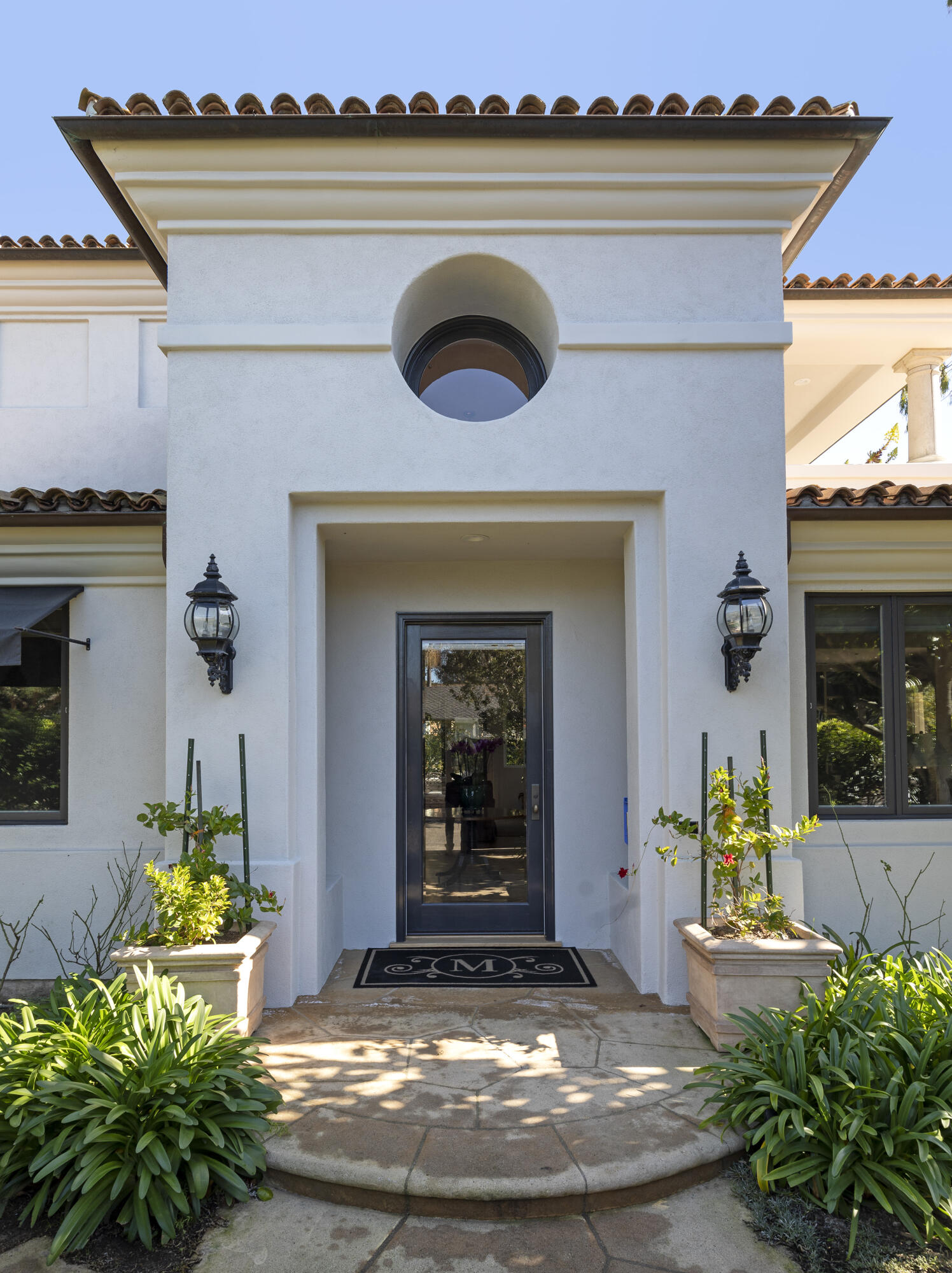 1138 Hill Road Santa Barbara, CA 93108 - Photo 24 of 25 a view of a house with potted plants and a dining table under an umbrella