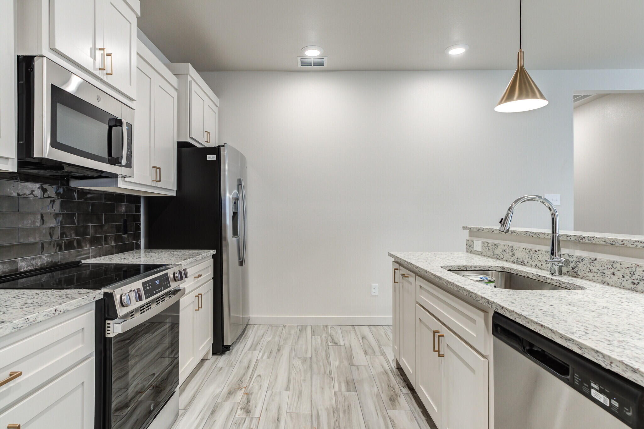 7030 41st Street Lubbock, TX 79407 - Photo 24 of 44 a kitchen with stainless steel appliances granite countertop a sink a stove and a refrigerator