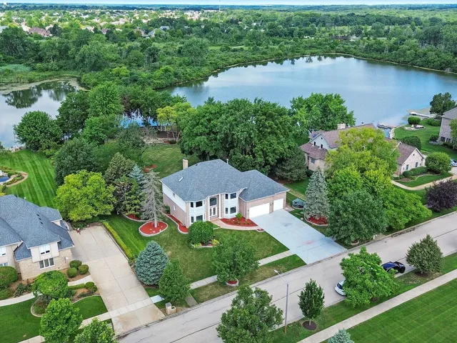 an aerial view of a house with a garden and lake view