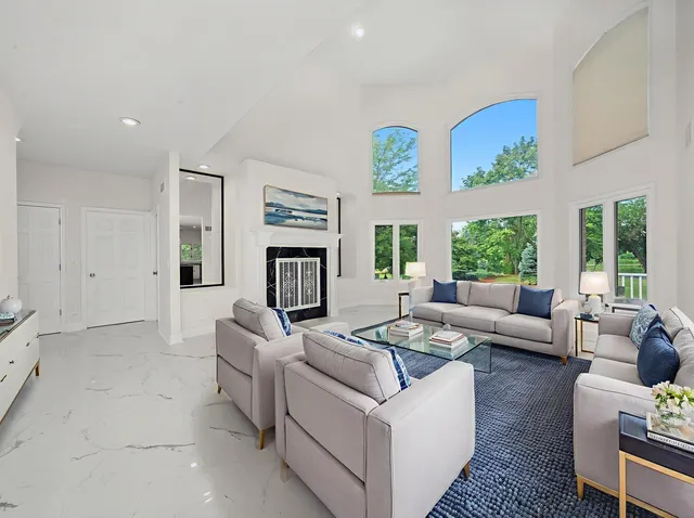 a kitchen with granite countertop a refrigerator a stove a sink dishwasher and white cabinets with wooden floor