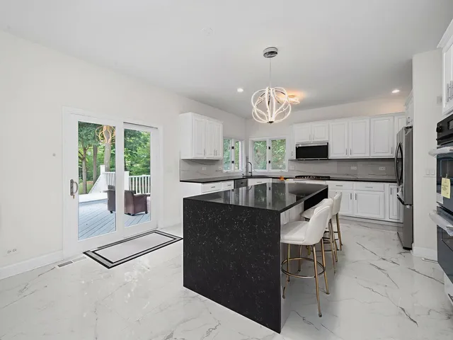 a kitchen with granite countertop a sink a stove top oven a counter space and cabinets
