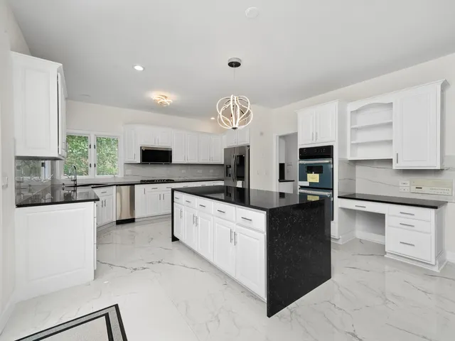 a kitchen with granite countertop a stove and a sink