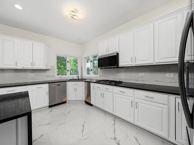 a kitchen with white cabinets and sink