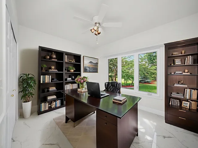 an empty room with a ceiling fan and window