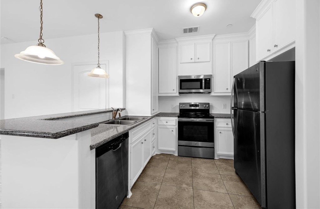 6122 West Mt Houston Road, Unit 4 Houston, TX 77088 - Photo 2 of 11 a kitchen with granite countertop stainless steel appliances and a sink