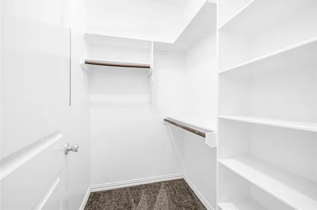 a view of walk in closet with empty racks